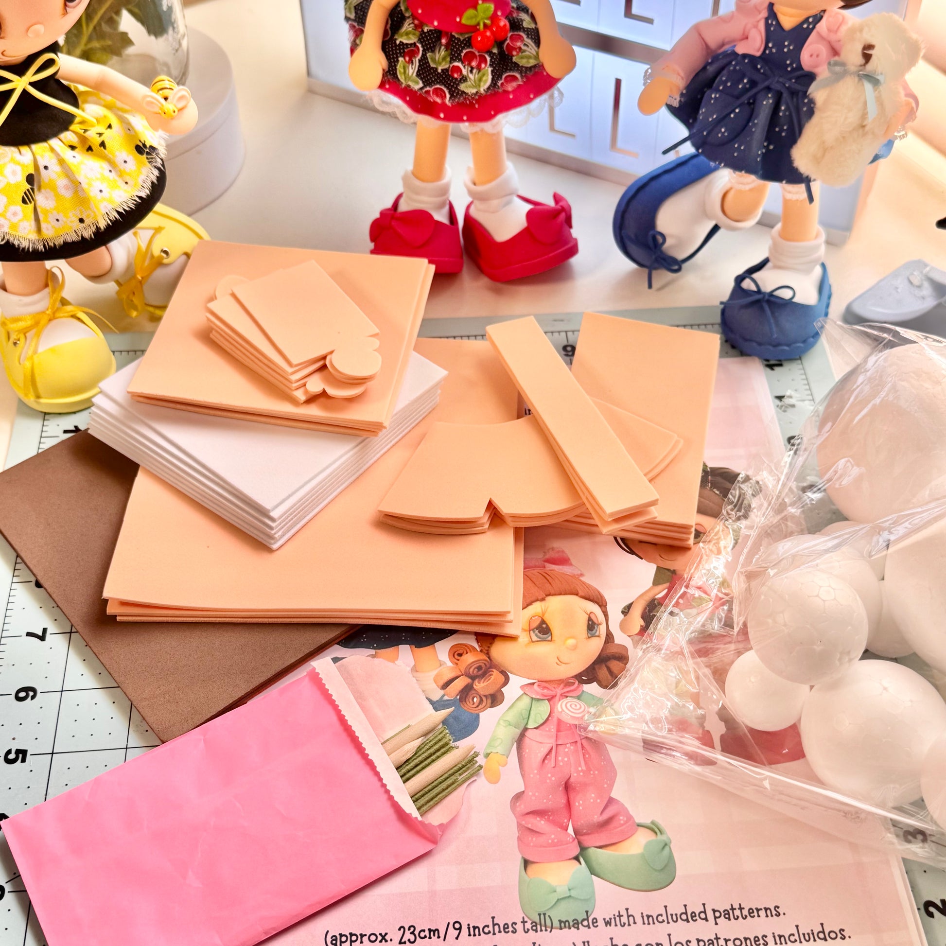 Primer plano de bolas de unicel, foami color piel y alambres para armar fofuchas - Close-up of foam balls, skin-tone foam, and wires for doll assembly.